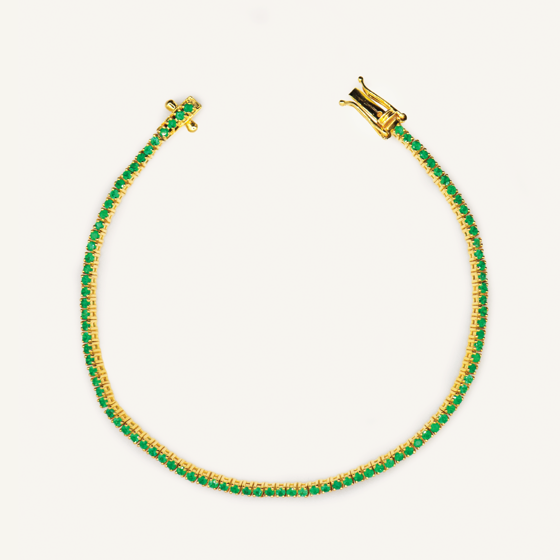 Grace Tennis Bracelet — vivid green round emerald stones set in yellow gold, studio product shot — Stone Symphony