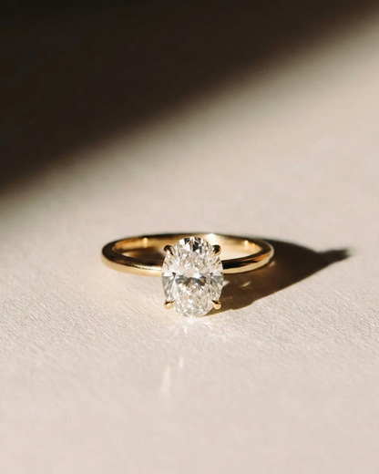 Oval Solitaire Diamond Ring on beige surface — yellow gold with large oval diamond — Stone Symphony