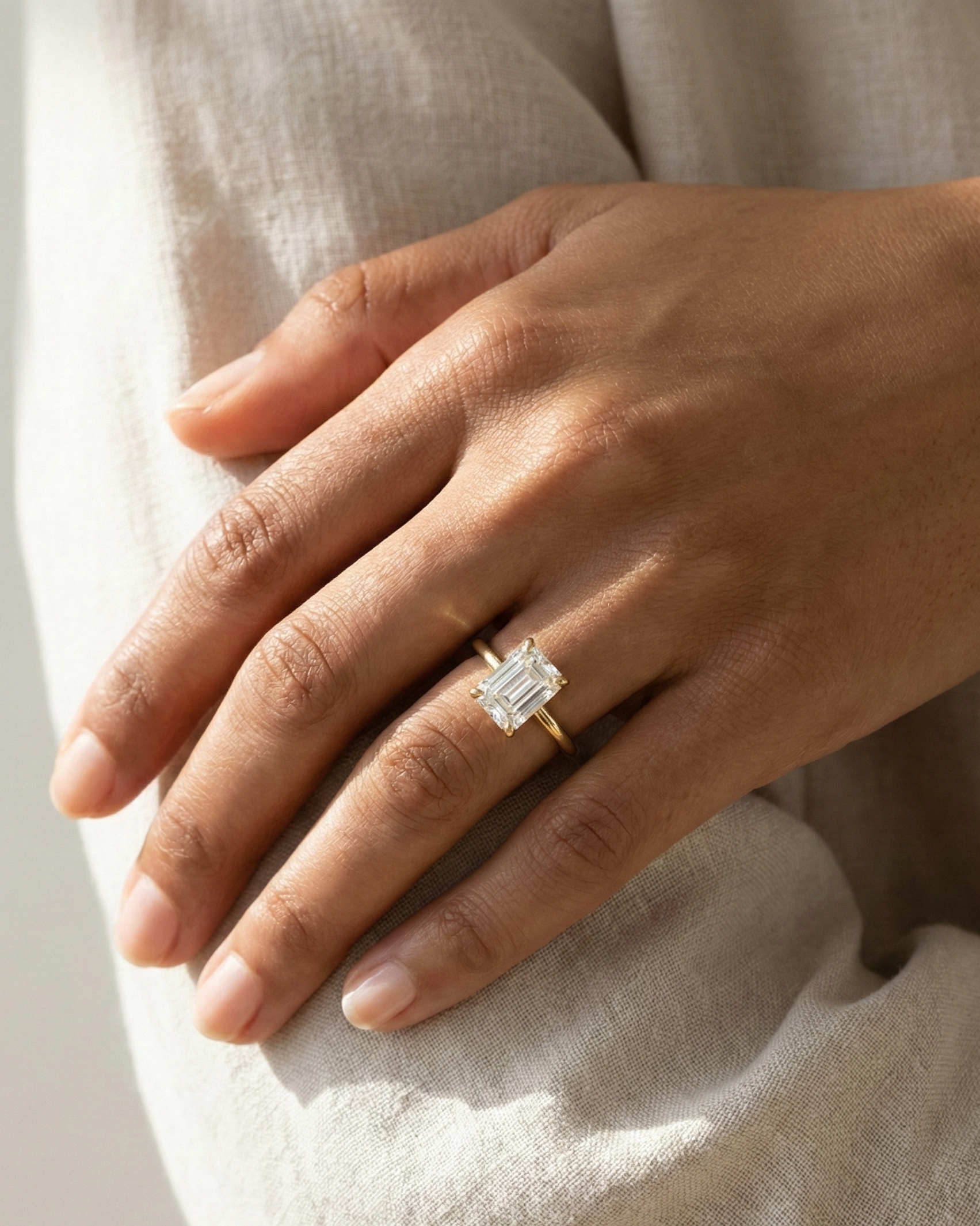 Emerald Cut Diamond Solitaire Ring on hand — large emerald-cut diamond in yellow gold — Stone Symphony