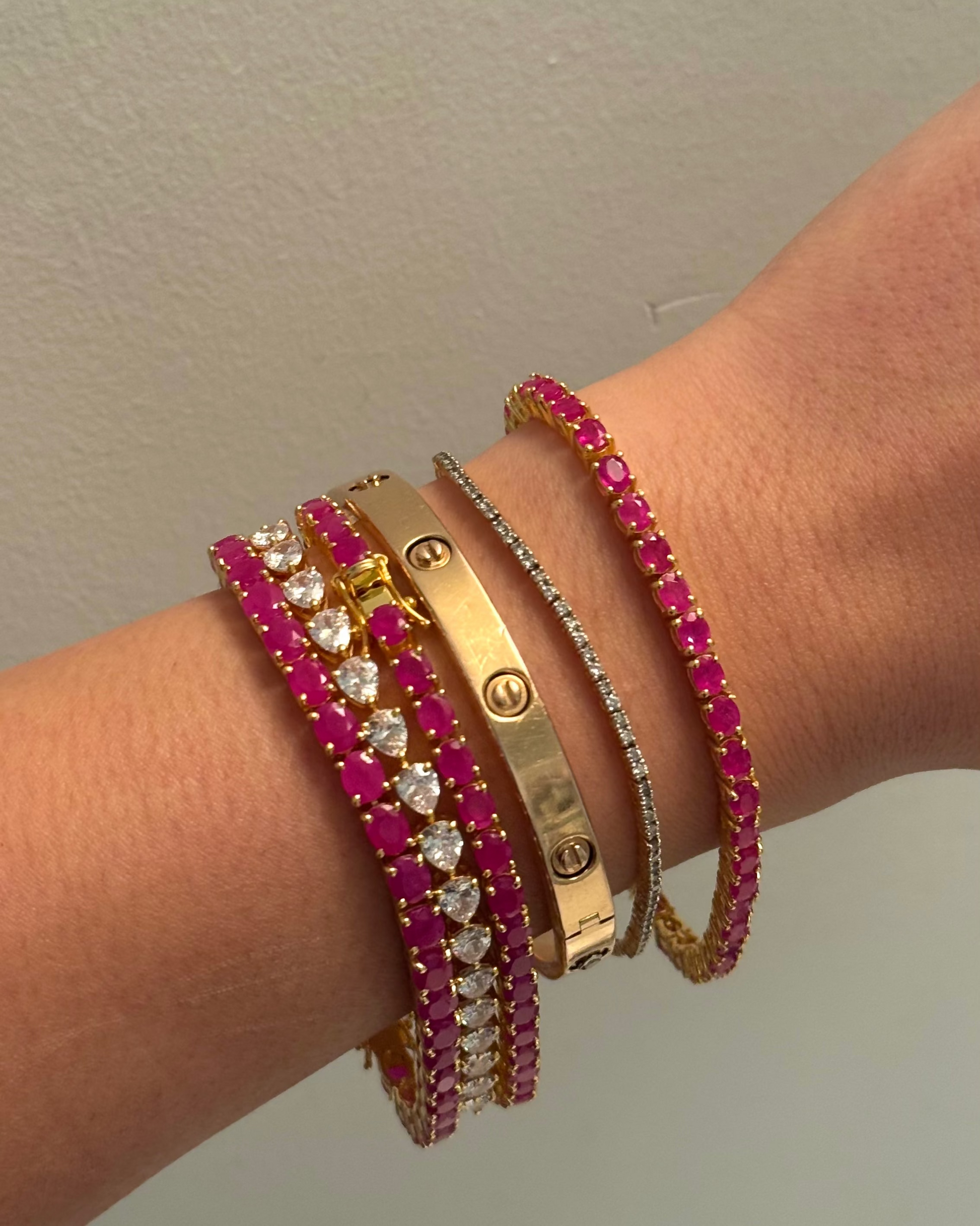 Seraphina Ruby Tennis Bracelet 18K gold vermeil on wrist — oval ruby stones in warm gold — Stone Symphony