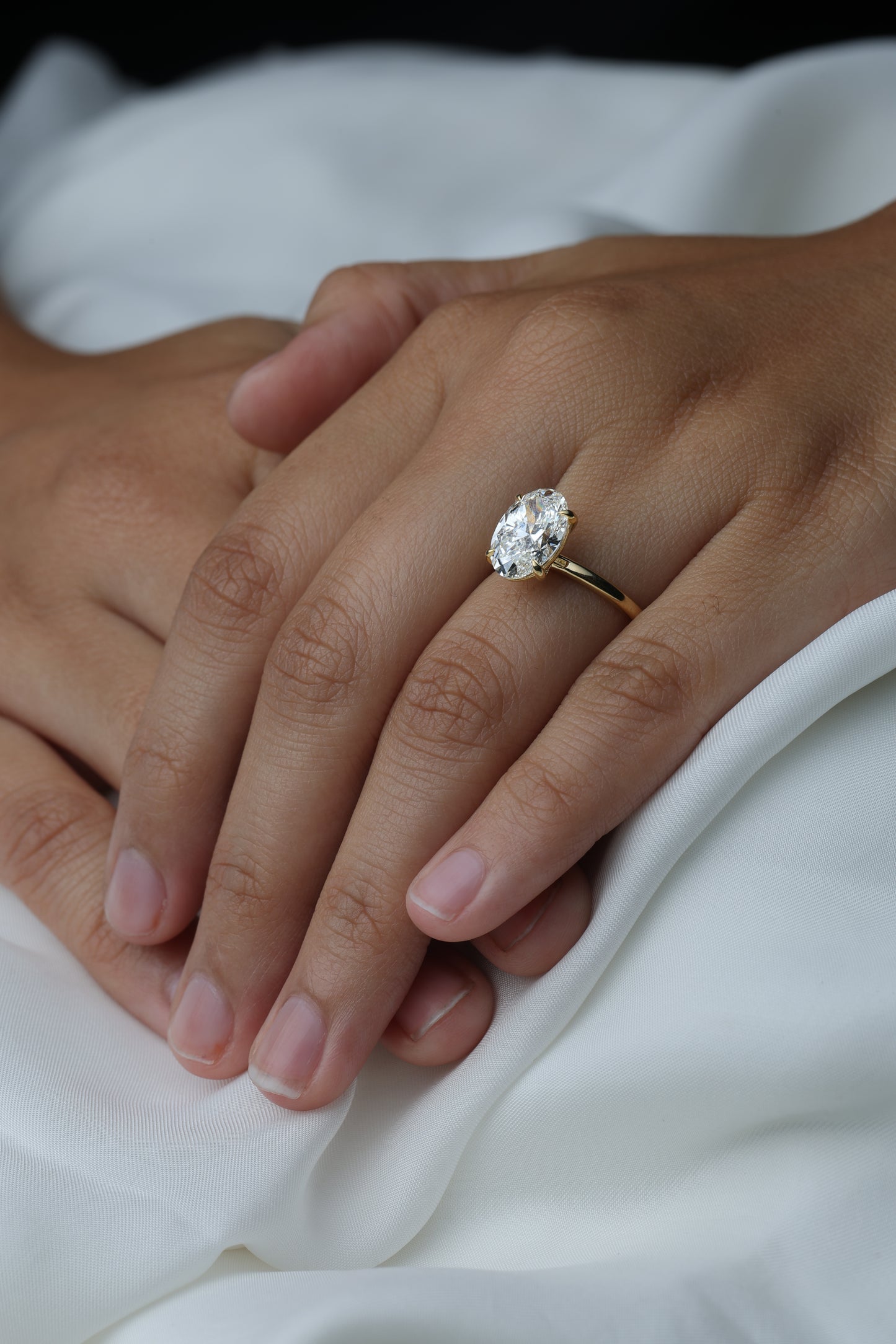 Oval Solitaire Diamond Ring on hand — oval-cut diamond solitaire, white background — Stone Symphony